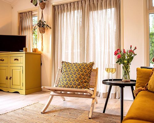 Gezellige zithoek met fauteuil en kussens bij raam