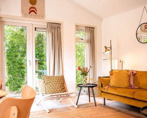 Warmme woonkamer met bank, houten tafel en sfeerverlichting