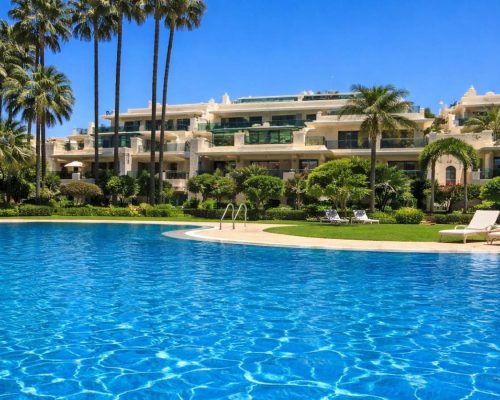 Large swimmingpool at Marbella resort with palm trees