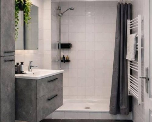 Badkamer met douche, wastafel en opbergruimte